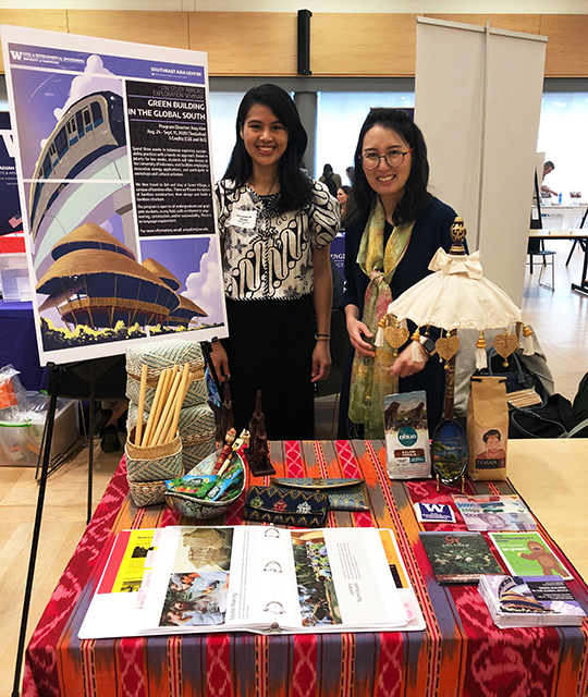 Amy Kim and Lysandra Medal standing at their booth at a conference