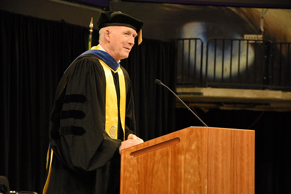 Keynote speaker and Professor Emeritus Steve Kramer delivering a speech at a podium during the ceremony.