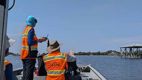 Group of people in orange safety vests on a boat