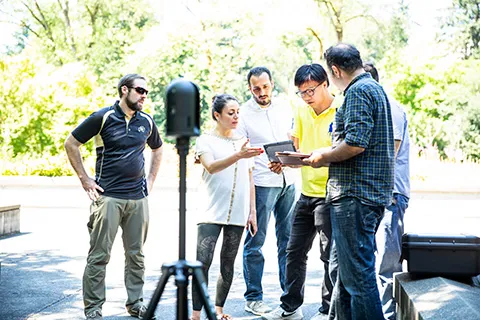 A group of researchers outdoors looking at documents