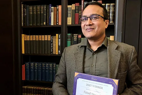 Faisal Hossain holding an award certificate