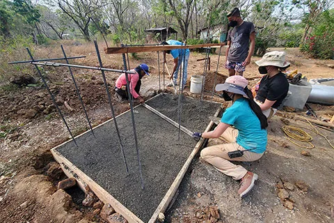 EWB members and community members work on the foundation for a compostable latrine