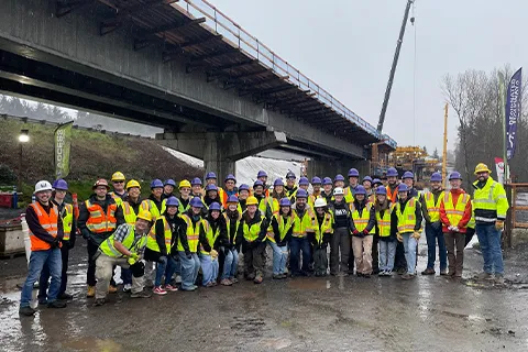 Group of people posing for a photo wearing construction gear