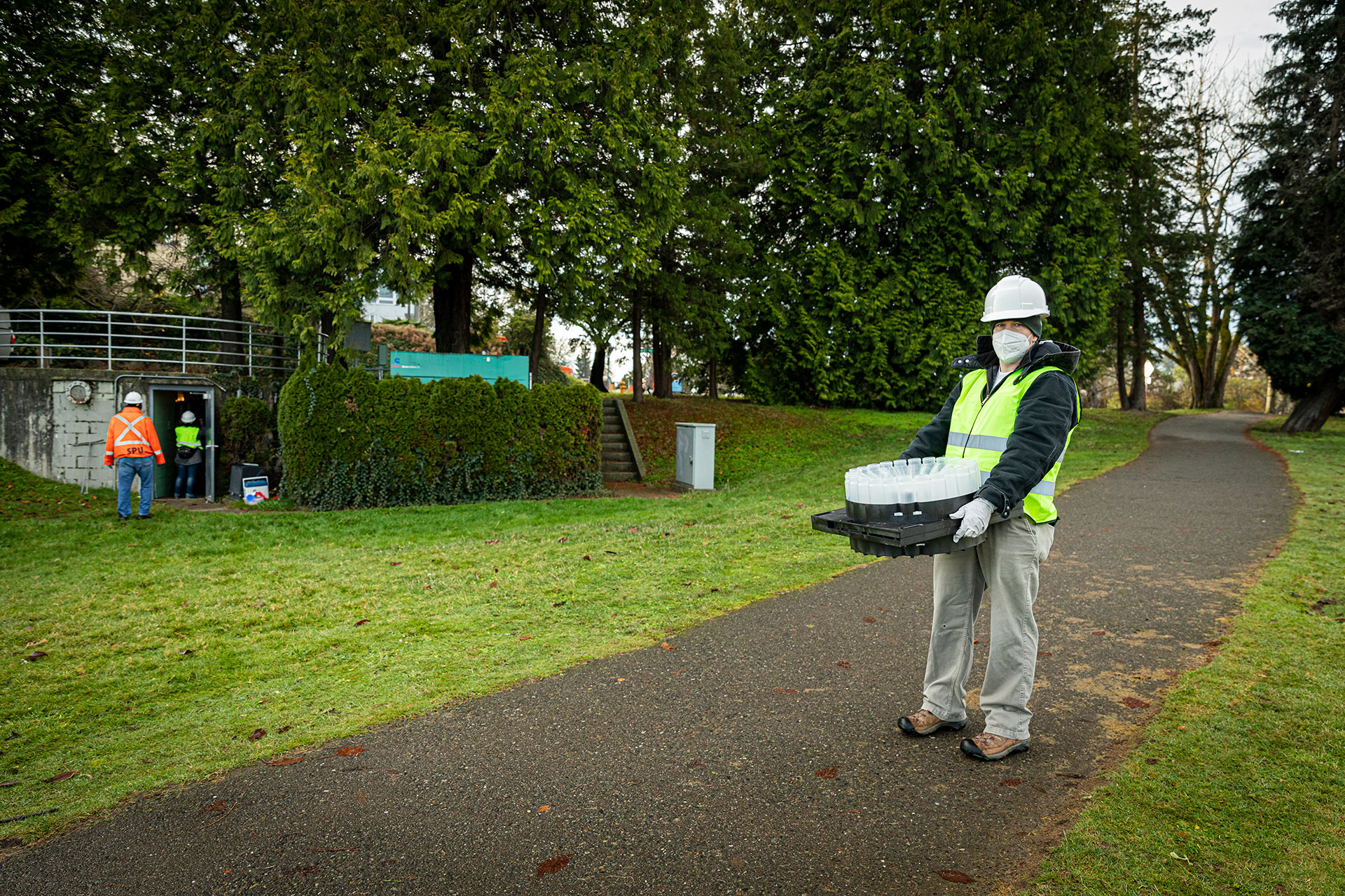 A researcher carrying an empty container rack