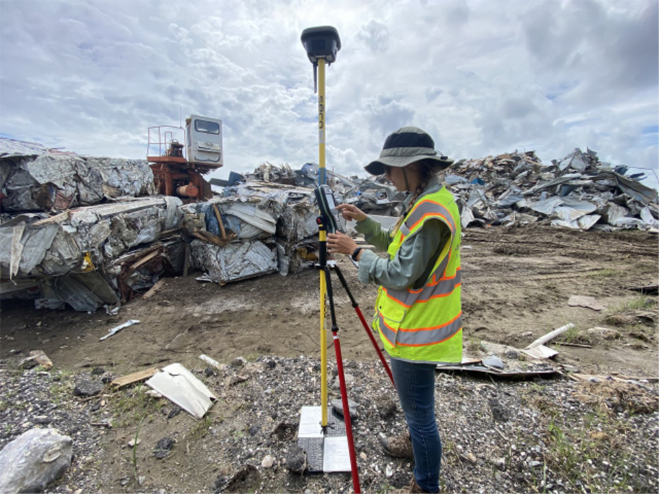 A researcher conducting research in front of building debris