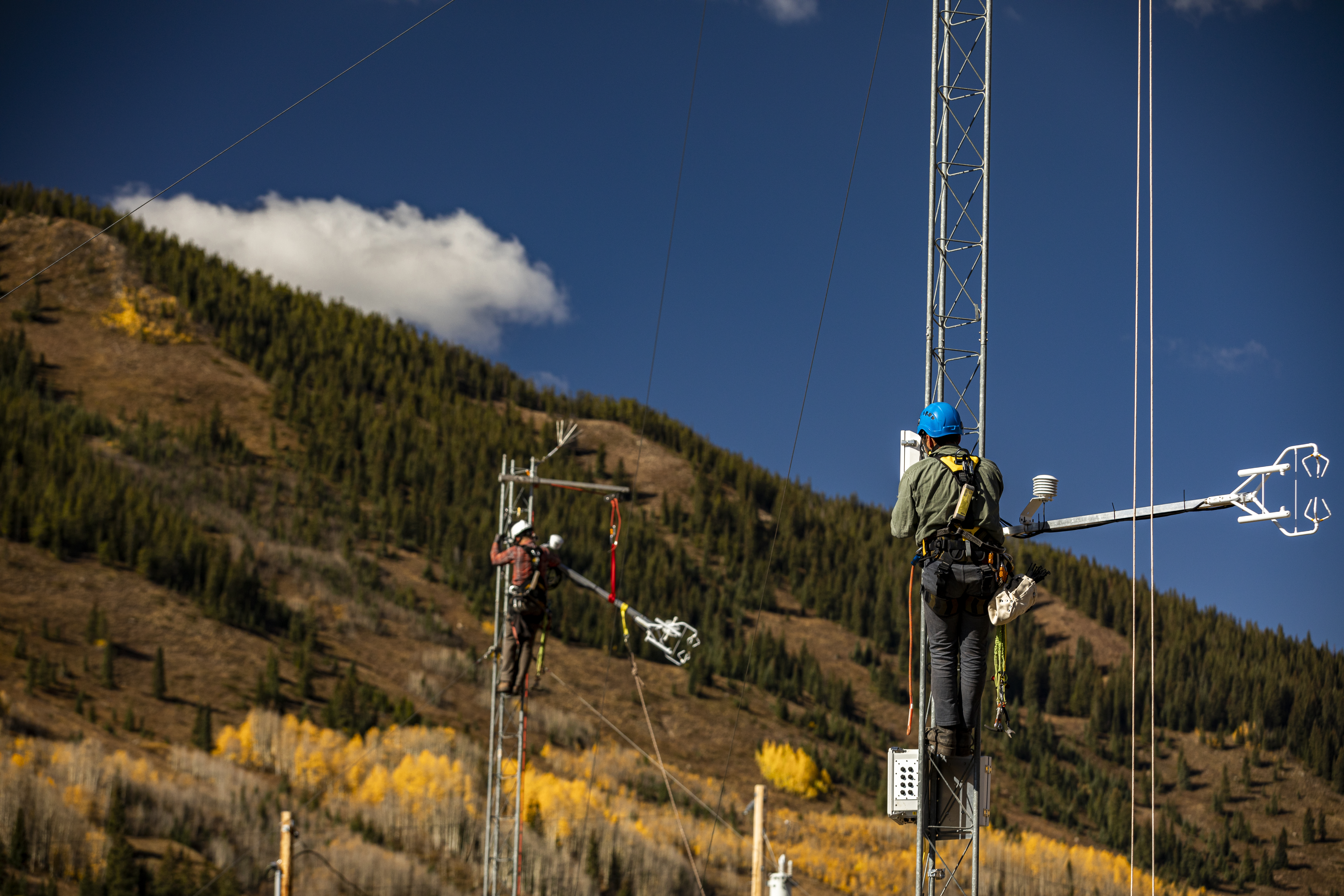 Researchers perched in mid-air on two separate towers