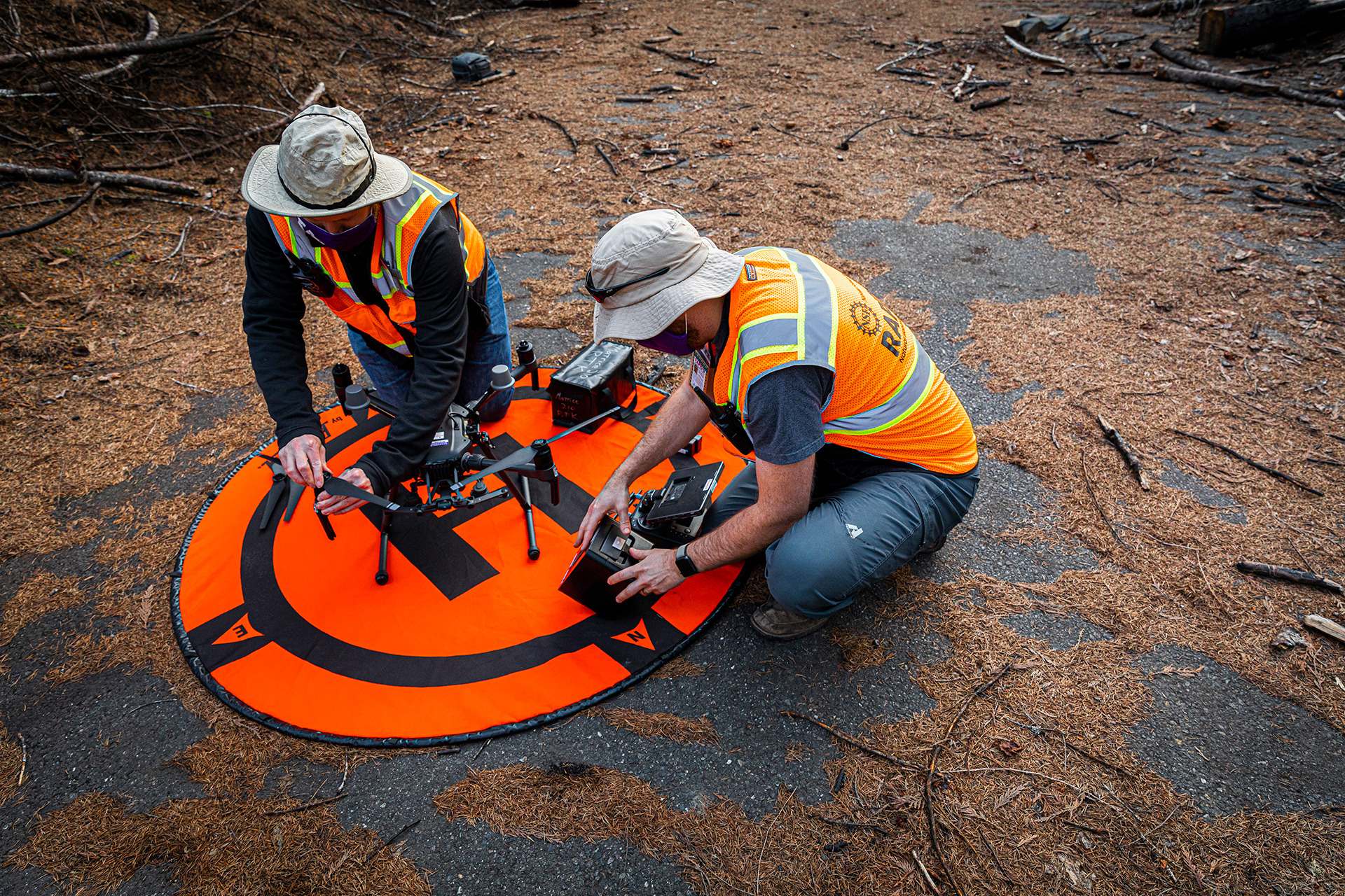 Two researchers adjusting a drone