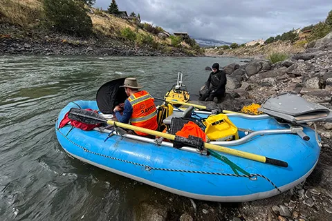 researchers in a raft on a river