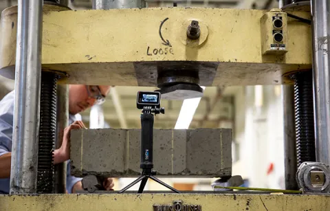 Julian Yamaura working in a lab with a camera in front of him